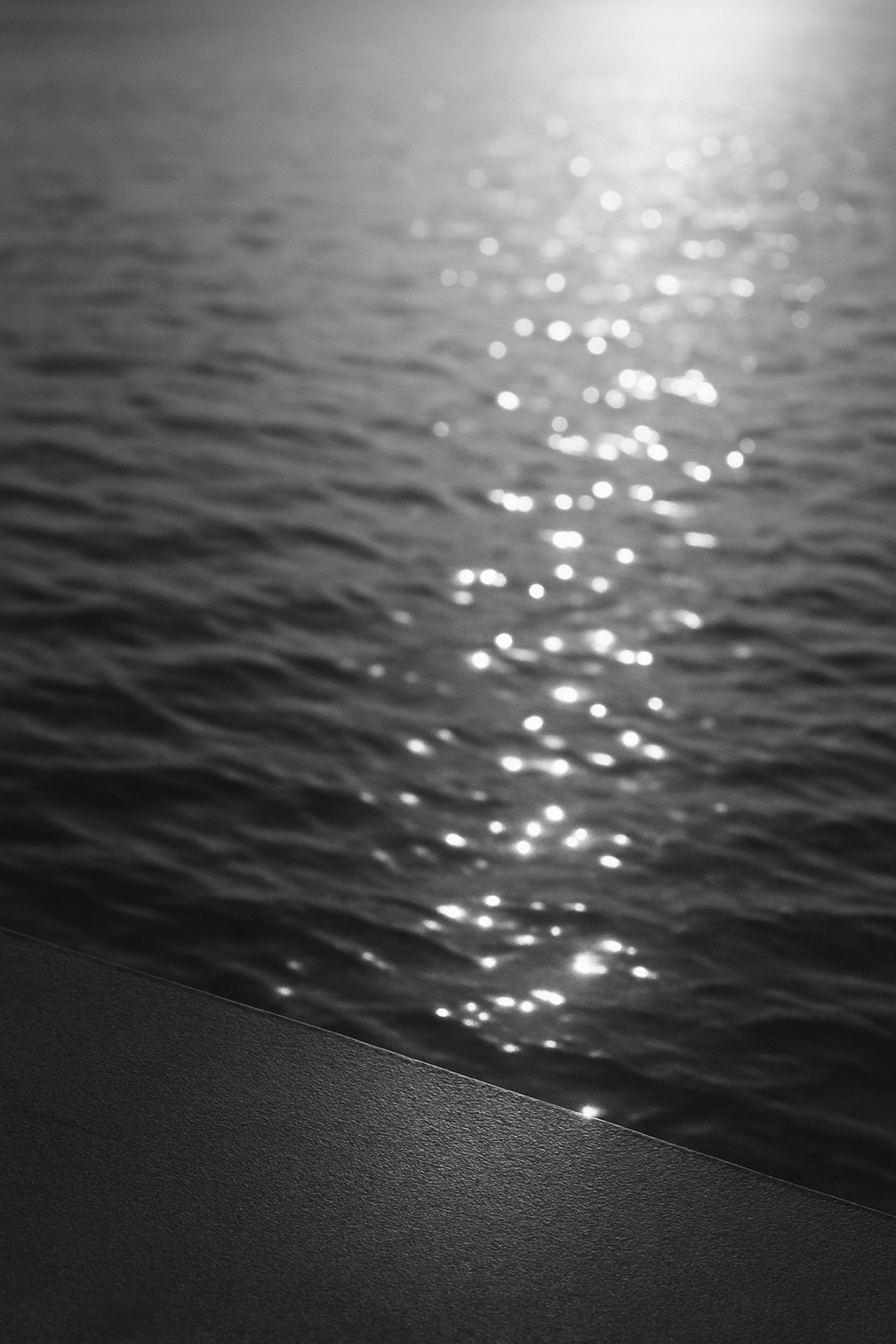 Schwarz-weiss Fotografie einer Wasseroberfläche. Sonnenlicht reflektiert in funkelnden Punkten auf den Wellen, die Bewegung und Leichtigkeit andeuten. Minimalistisch, ruhig, modern.